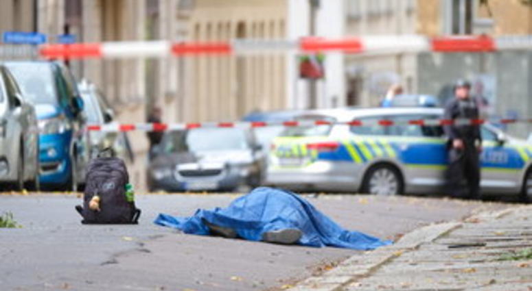 A body lies on a road in Halle, Germany after a shooting incident. A gunman fired several shots on Wednesday in German city of Halle and at least two got killed, according to local media FOCUS online. (Sebastian Willnow/dpa via AP)
