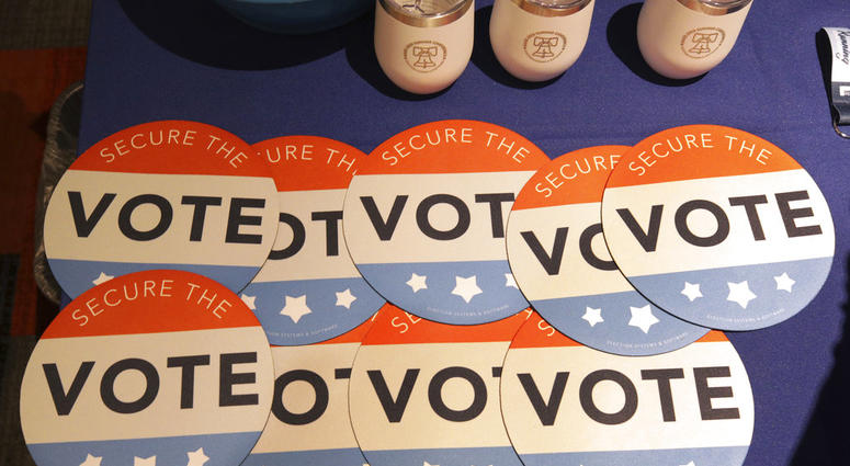 FILE - In this July 14, 2018, file photo, computer mouse pads with Secure the Vote logo on them are seen on a vendor's table at a convention of state secretaries of state in Philadelphia. (AP Photo/Mel Evans, File) FILE - In this July 14, 2018, file photo, computer mouse pads with Secure the Vote logo on them are seen on a vendor's table at a convention of state secretaries of state in Philadelphia. (AP Photo/Mel Evans, File)