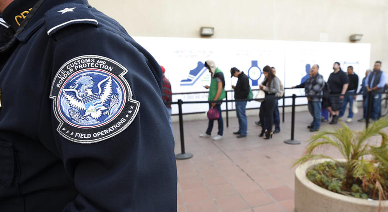 In this Dec. 10, 2015, file photo, pedestrians crossing from Mexico into the United States at the Otay Mesa Port of Entry wait in line in San Diego.