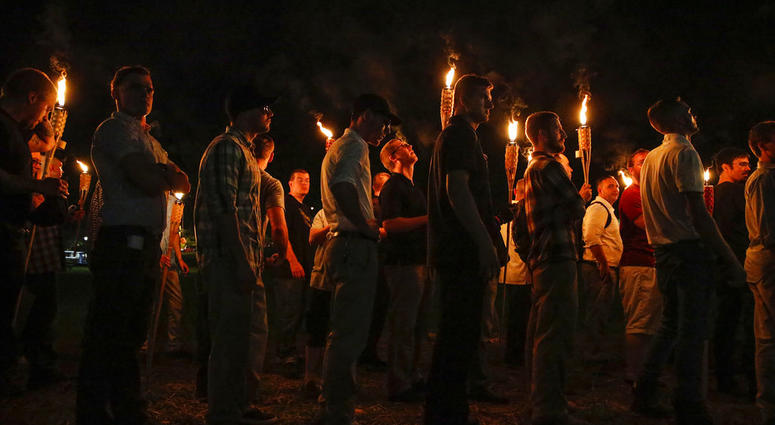 In this Aug. 11, 2017, file photo, multiple white nationalist groups march with torches through the University of Virginia campus in Charlottesville, Va. (Mykal McEldowney/The Indianapolis Star via AP, File)