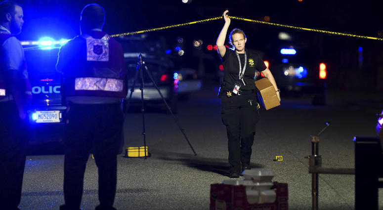 A member of the sheriff's department exits the crime scene on Ashton Drive in the Vintage Place neighborhood where several members of law enforcement were shot, one fatally, Wednesday, Oct. 3, 2018, in Florence, S.C. (AP Photo/Sean Rayford)
