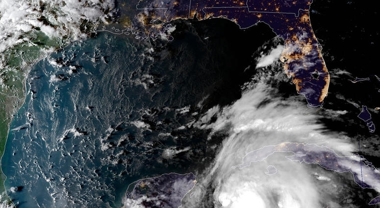 This satellite image provided by the National Oceanic and Atmospheric Administration shows a view of Tropical Storm Michael, lower right, churning as it heads toward the Florida Panhandle, Sunday, Oct. 7, 2018, at 6:52 p.m. Eastern Time. (NOAA via AP)
