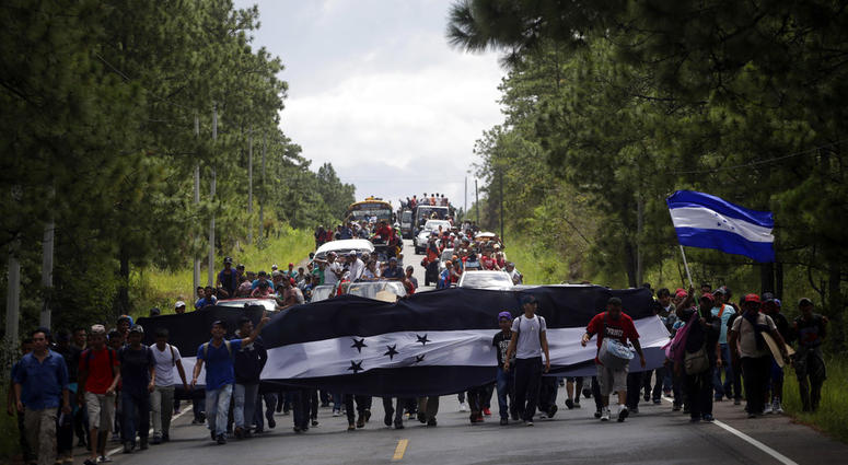 Hondurans march in a caravan of migrants moving toward the country's border with Guatemala in a desperate attempt to flee poverty and seek new lives in the United States, on Monday, Oct. 15, 2018. (AP Photo/Moises Castillo)