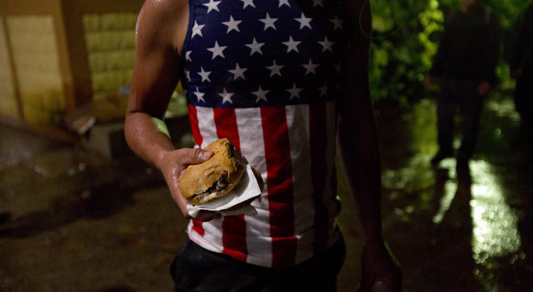 A Honduran migrant holds a sandwich at an improvised shelter in Chiquimula, Guatemala, Tuesday, Oct. 16, 2018. (AP Photo/Moises Castillo)