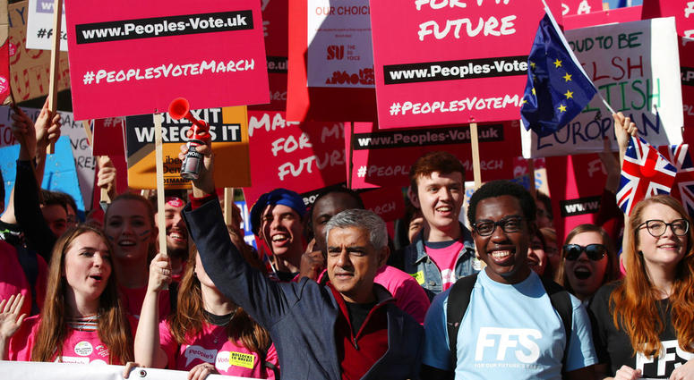 Mayor of London Sadiq Khan, front centre, holds a klaxon horn, as he joins protesters in the People's Vote March for the Future, in London, Saturday Oct. 20, 2018.