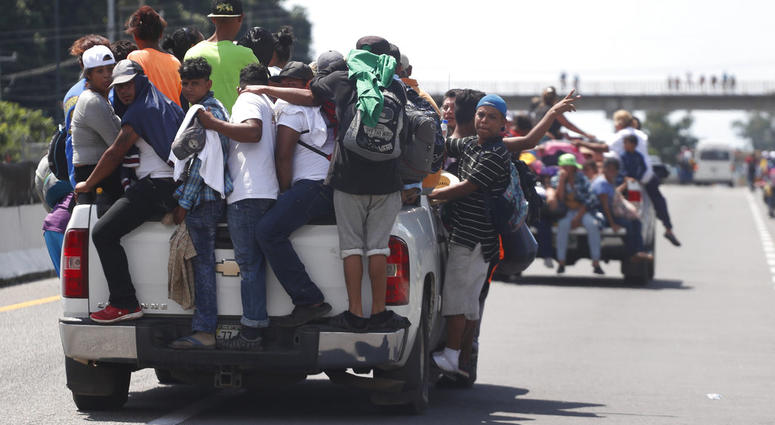 Central American migrants making their way to the U.S. in a large caravan cling to the trucks of drivers who offered them free rides, as they arrive to Tapachula, Mexico, Sunday, Oct. 21, 2018. (AP Photo/Moises Castillo)