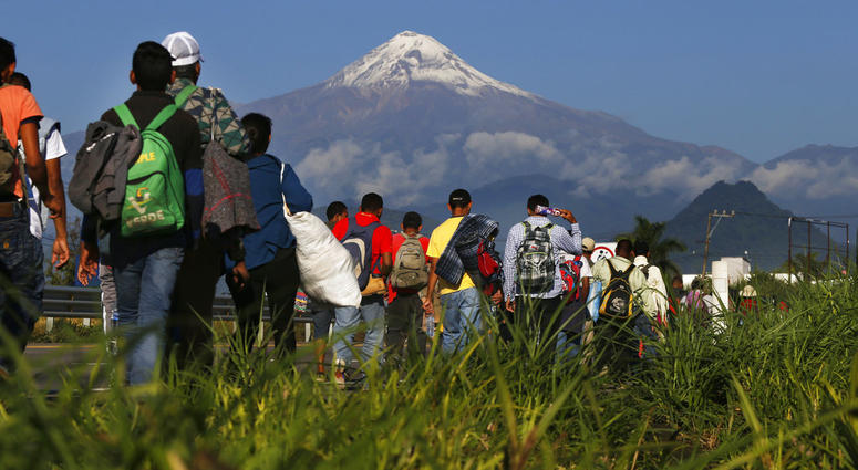 Central American migrants begin their morning trek as part of a thousands-strong caravan hoping to reach the U.S. border, as they face the Pico de Orizaba volcano