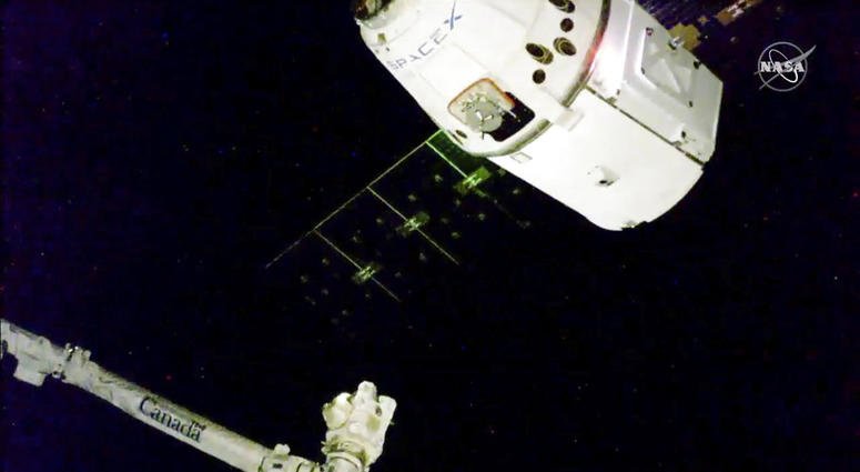 In this image taken from NASA Television, the SpaceX Dragon cargo spacecraft approaches the robotic arm for docking to the International Space Station, Saturday, Dec. 8, 2018.
