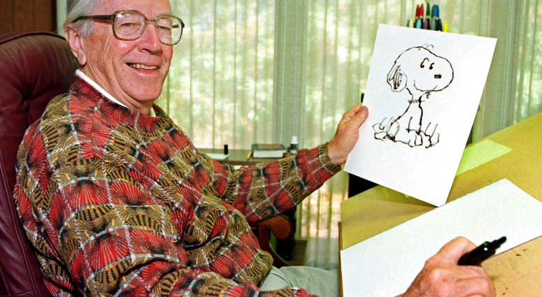 n this Feb. 12, 2000, file photo, cartoonist Charles M. Schulz displays a sketch of his beloved character "Snoopy" in his office in Santa Rosa, Calif. Apple has struck a deal with DHX Media to produce new “Peanuts” content