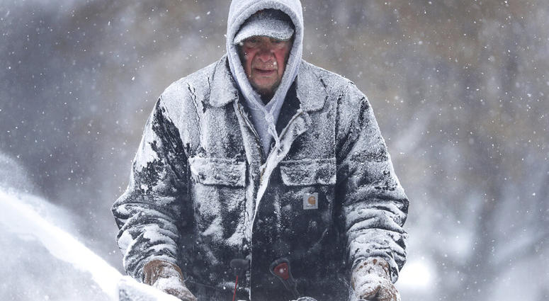 Gary Verstegen clears a sidewalk as a winter storm moves through Wisconsin on Monday, Jan. 28, 2019, in Little Chute, Wis