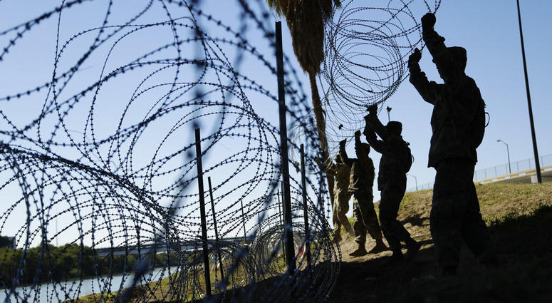In this Friday, Nov. 16, 2018, file photo, members of the U.S. military install multiple tiers of concertina wire along the banks of the Rio Grande near the Juarez-Lincoln Bridge at the U.S.-Mexico border,