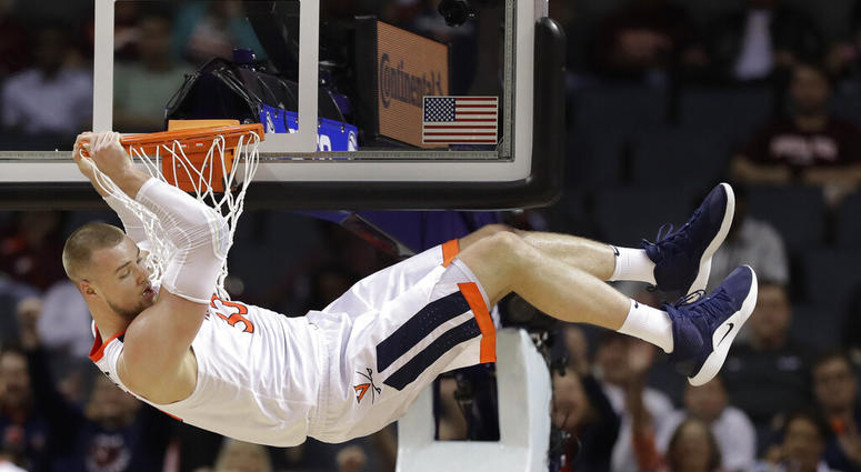 Virginia's Jack Salt (33) hangs from the rim after a dunk against North Carolina State during the second half of an NCAA college basketball game in the Atlantic Coast Conference tournament in Charlotte, N.C., March 14, 2019. (AP Photo/Chuck Burton)