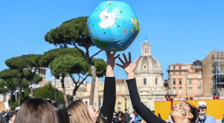Students play with an inflatable globe as they march to demand action on climate change, in Rome, Friday, March 15, 2019. (Alessandro Di Meo/ANSA via AP)