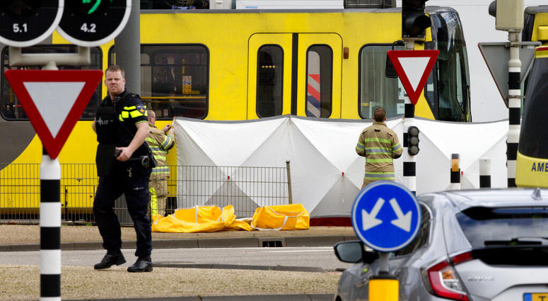 Rescue workers install a screen on the spot where a body was covered with a white blanket following a shooting in Utrecht, Netherlands, Monday, March 18, 2019. (AP Photo/Peter Dejong)