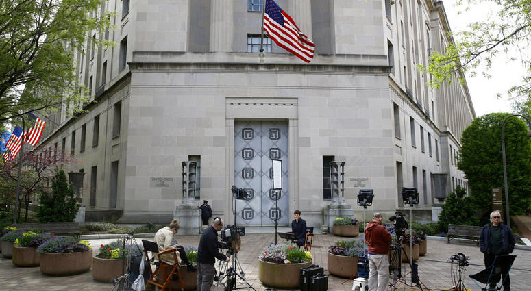 Television news crews work outside the Department of Justice building, Wednesday, April 17, 2019, in Washington. (AP Photo/Patrick Semansky)