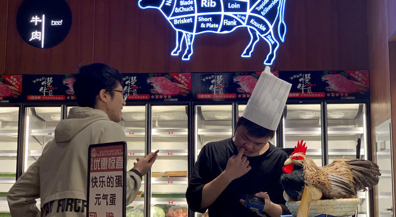 A worker at the imported beef section of a supermarket that used to carry U.S. products chats with another in Beijing on Tuesday, May 14, 2019. (AP Photo/Ng Han Guan)