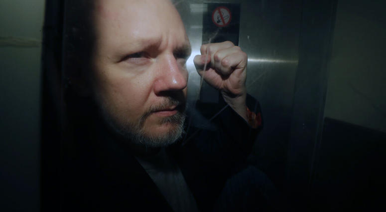 In this May 1, 2019, file photo, WikiLeaks founder Julian Assange puts his fist up as he is taken from court in London. (AP Photo/Matt Dunham, File)