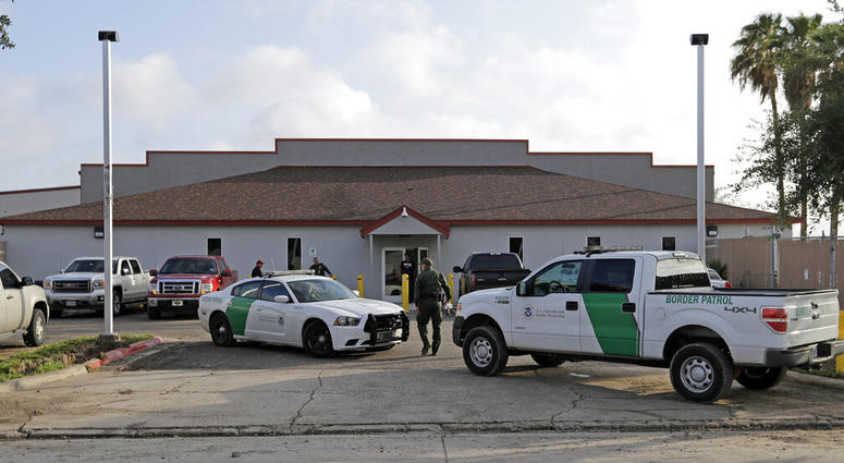 FILE - In this Saturday, June 23, 2018, file photo, a U.S. Border Patrol Agent walks between vehicles outside the Central Processing Center in McAllen, Texas. Advocates were shocked to find an underage mom and her tiny, premature newborn daughter huddled