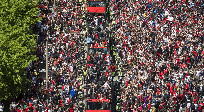 Members of the Toronto Raptors NBA basketball championship team ride on buses during a victory parade in Toronto, Monday, June 17, 2019. (Tijana Martin/The Canadian Press via AP)