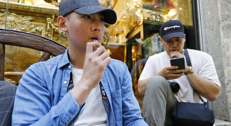 In this Monday, June 17, 2019, photo, Joshua Ni, 24, and Fritz Ramirez, 23, vape from electronic cigarettes in San Francisco. (AP Photo/Samantha Maldonado) In this Monday, June 17, 2019, photo, Joshua Ni, 24, and Fritz Ramirez, 23, vape from electronic cigarettes in San Francisco. (AP Photo/Samantha Maldonado)