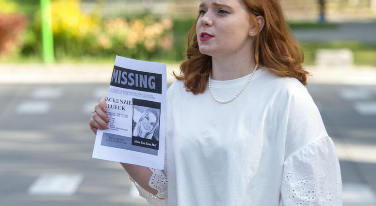 In this Saturday, June 22, 2019 photo, Ashley Fine stops motorists in Liberty Park in Salt Lake City, as she hands out flyers with Mackenzie Lueck's photo on it. Police and friends are investigating the disappearance of the 23-year-old University of Utah