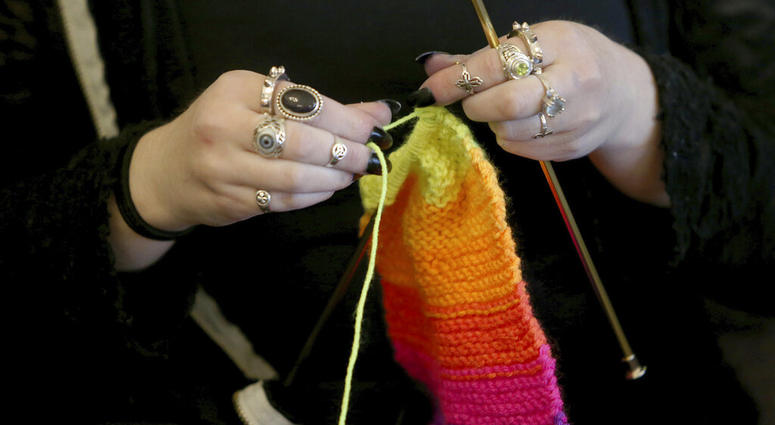 FILE - This April 30, 2018 file photo shows a woman knitting in Silverdale Wash. A free, 8-million strong social network for knitters, crocheters and others in the fiber arts has banned any talk of President Donald Trump and his administration. The new po