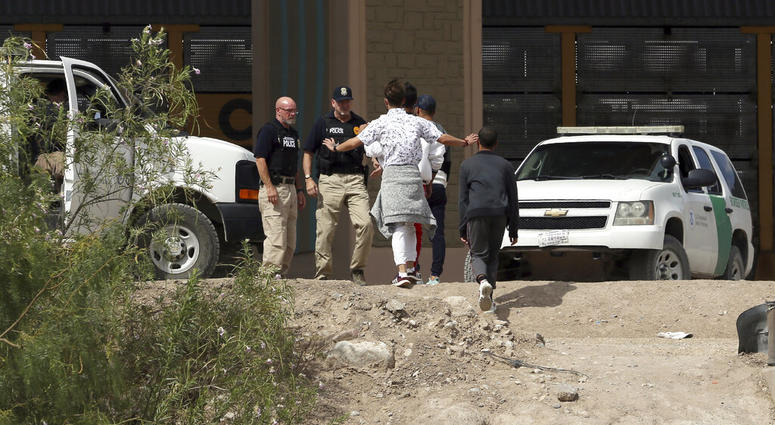 In this July 4, 2019 file photo, a group of asylum seekers cross the border between El Paso, Texas, and Juarez, Chihuahua, Mexico, Thursday, July 4, 2019. (Mark Lambie/The El Paso Times via AP)