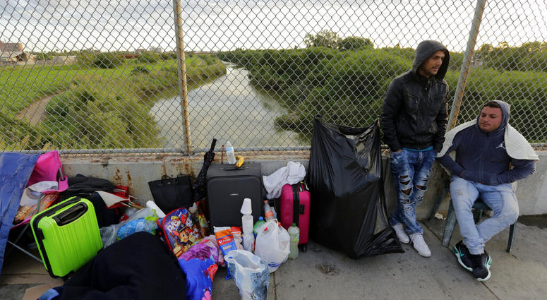 FILE - In this Nov. 2, 2018, file photo, Yenly Morales,left, and Yenly Herrera, right, immigrants from Cuba seeking asylum in the United States, wait on the Brownsville and Matamoros International Bridge in Matamoros, Mexico. The U.S. government will expa