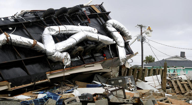 Power company lineman work to restore power after a tornado hit Emerald Isle, N.C. as Hurricane Dorian moved up the East coast on Thursday, Sept. 5, 2019. (AP Photo/Tom Copeland)