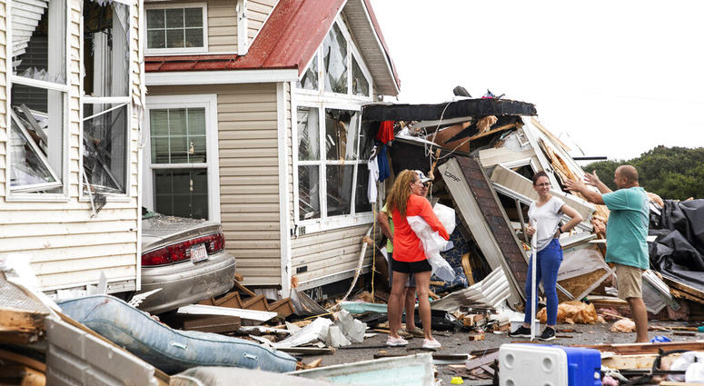 Residents of the Boardwalk RV Park discuss the path of a possible waterspout or tornado, generated by Hurricane Dorian, struck the area, Thursday, Sept. 5, 2019, in Emerald Isle, N.C. (Julia Wall/The News & Observer via AP)