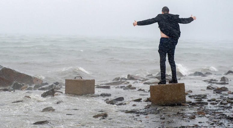 An unidentified man raises his arms in the winds from Hurricane Dorian along the Halifax harbor in Dartmouth, Nova Scotia, Canada, on Saturday, Sept. 7, 2019. (Andrew Vaughan/The Canadian Press via AP)