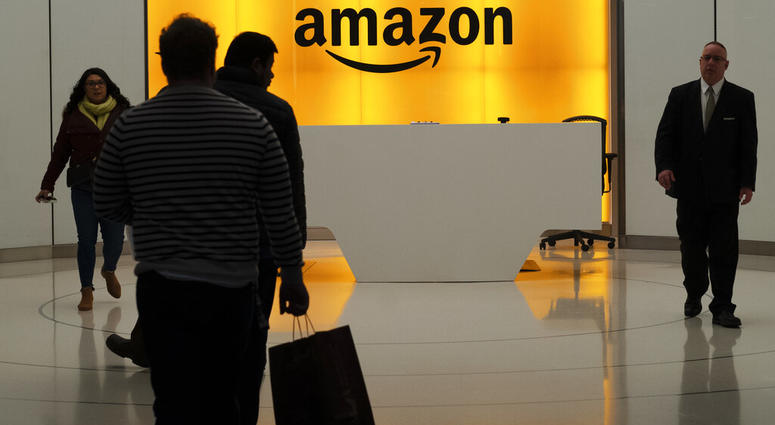 FILE - In this Feb. 14, 2019, file photo people walk into the lobby for Amazon offices in New York. The online shopping giant is holding job fairs across the country next week, aiming to hire more than 30,000 people by early next year, a 5% bump in its to