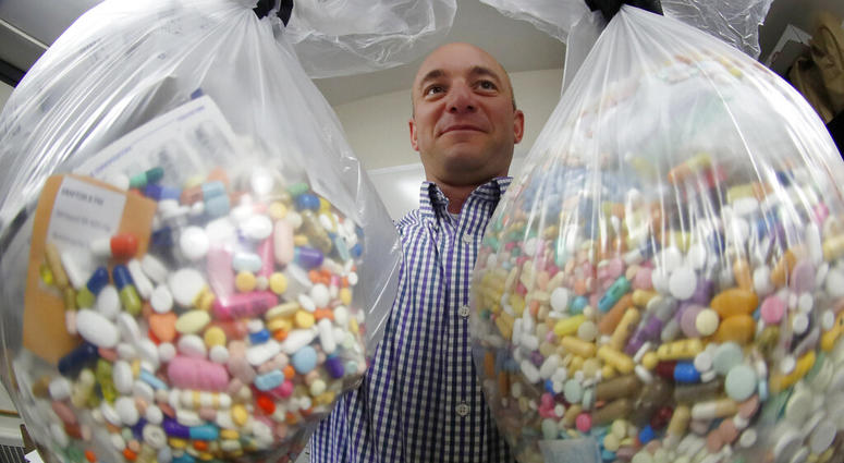 Narcotics detective Ben Hill, with the Barberton Police Department, shows two bags of medications that are are stored in their headquarters and slated for destruction, Wednesday, Sept. 11, 2019, in Barberton, Ohio.