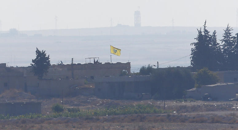 A flag of Kurdish People's Protection Units, or YPG, flies on a building in the Syrian town of Tel Abyad, Tuesday, Oct. 8, 2019. (AP Photo/Lefteris Pitarakis)