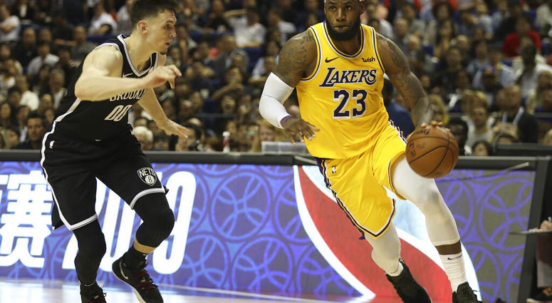 Los Angeles Lakers' Lebron James, right, drives against Brooklyn Nets' Rodions Kurucs, left, during their preseason NBA game in Shanghai, China, Thursday, Oct. 10, 2019. (AP Photo)