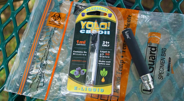 FILE - In this May 8, 2019, file photo, a Yolo! brand CBD oil vape cartridge sits alongside a vape pen on a biohazard bag on a table at a park in Ninety Six, S.C. (AP Photo/Allen G. Breed, File) FILE - In this May 8, 2019, file photo, a Yolo! brand CBD oil vape cartridge sits alongside a vape pen on a biohazard bag on a table at a park in Ninety Six, S.C. (AP Photo/Allen G. Breed, File)