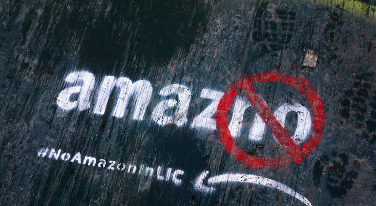 FILE- In this Nov. 16, 2018, file photo graffiti has been painted on a sidewalk by someone opposed to the location of an Amazon headquarters in the Long Island City neighborhood in the Queens borough of New York. Amazon said Thursday, Feb. 14, 2019, that