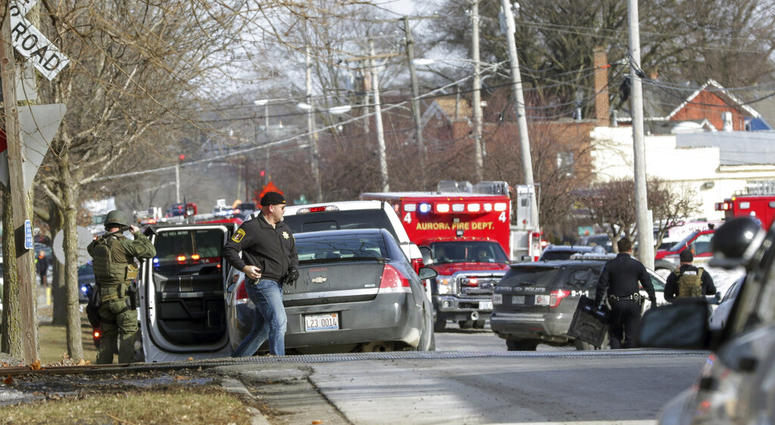 Law enforcement personnel gather near the scene of a shooting at an industrial park in Aurora, Ill., on Friday, Feb. 15, 2019. (Bev Horne/Daily Herald via AP)
