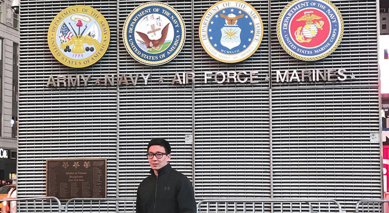 This November 2017 photo provided by Badamsereejid Gansukh shows him in front of a U.S. military recruiting office in New York's Times Square. Gansukh, whose recruiter told him his Turkish language skills would be an asset to the military, said he didn’t
