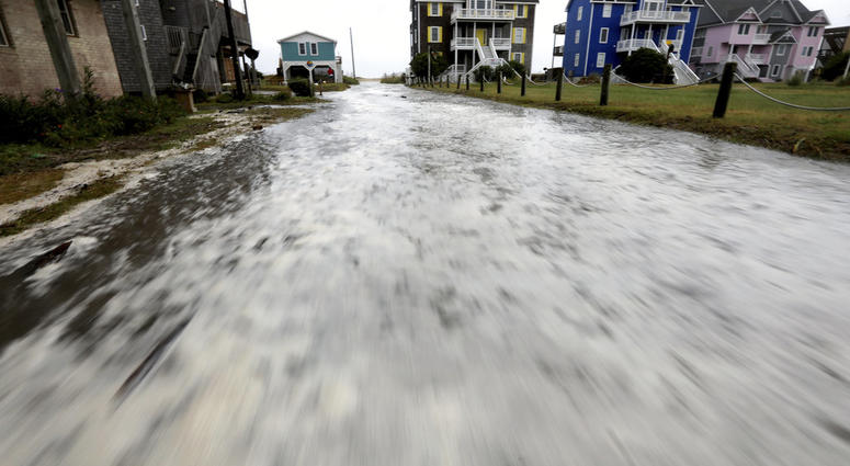 Ocean water rushes down Cape Hatteras Pier Drive in Frisco, N.C., on Hatteras Island as the effects of Hurricane Florence reach the area on Thursday, Sept. 13, 2018. (Steve Earley /The Virginian-Pilot via AP)
