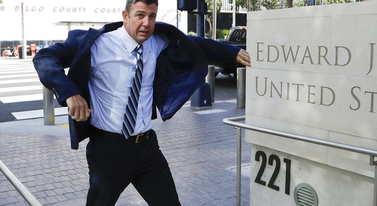 In this Aug. 23, 2018 photo, Rep. Duncan Hunter, R-Calif., pulls on his coat as he arrives for an arraignment hearing in San Diego. Winning re-election while indicted is a rare feat in U.S. history. (AP Photo/Gregory Bull)