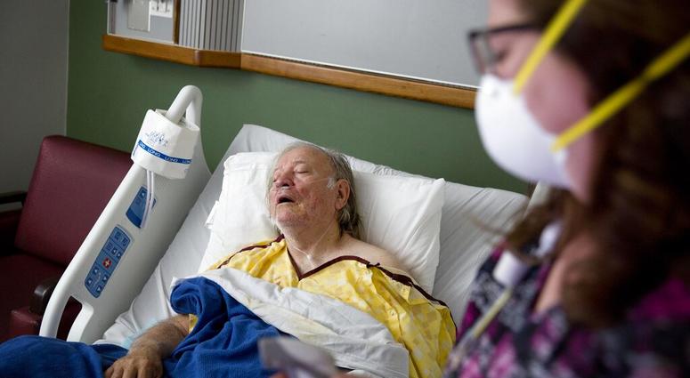 FILE - in this file photo, a flu patient is tended due by a nurse. As of January 2019, the current flu season is shaping up to be gentler than last winter’s unusually brutal one, health officials say. (AP Photo/David Goldman)
