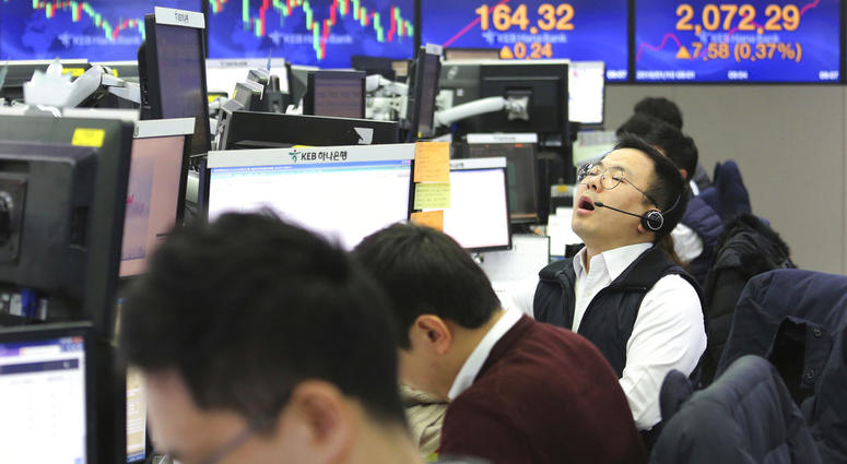 A currency trader shouts at the foreign exchange dealing room of the KEB Hana Bank headquarters in Seoul, South Korea, Thursday, Jan. 10, 2019. Asian markets were mostly lower Thursday. (AP Photo/Ahn Young-joon)