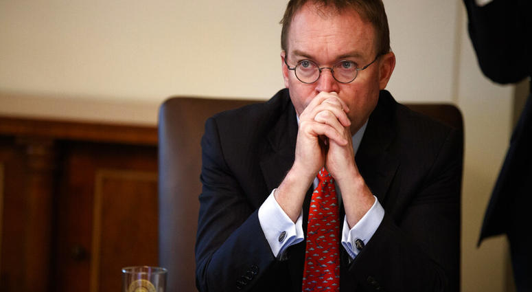 FILE- In this Jan. 2, 2019, file photo White House chief of staff Mick Mulvaney listens as President Donald Trump speaks during a cabinet meeting at the White House in Washington. Mulvaney says Trump is prepared for another government shutdown if Congress