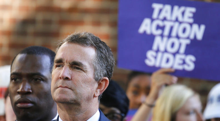 Virginia Gov. Ralph Northam, right, listens to speakers along with Richmond Mayor Levar Stoney, left, during a rally at the State Capitol in Richmond, Va., Tuesday, July 9, 2019. (AP Photo/Steve Helber)
