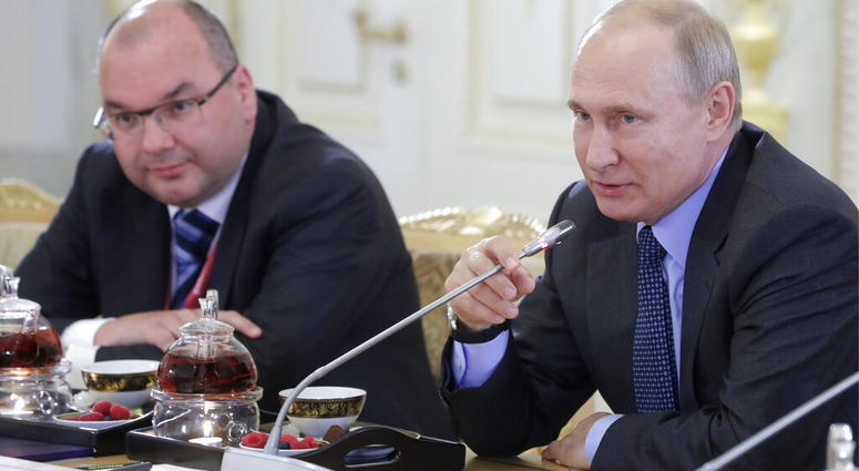 Russian President Vladimir Putin, right, speaks during a meeting with heads of world's leading news agencies. (Mikhail Metzel/TASS News Agency Pool Photo via AP)