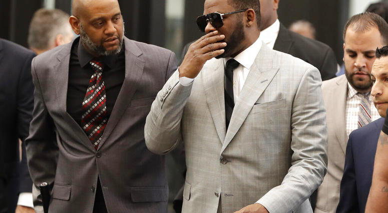 Musician R. Kelly, right, arrives at the Leighton Criminal Court building for an arraignment on new sex-related felonies Thursday, June 6, 2019, in Chicago. (AP Photo/Charles Rex Arbogast)
