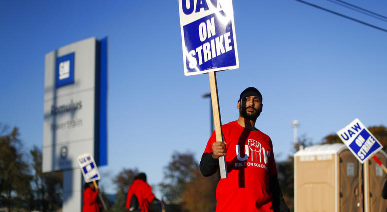 FILE - In this Oct. 9, 2019, file photo a member of the United Auto Workers walks the picket line at the General Motors Romulus Powertrain plant in Romulus, Mich. (AP Photo/Paul Sancya, File)