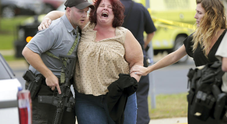 A women is escorted from the scene of a shooting at a software company in Middleton, Wis., Wednesday, Sept. 19, 2018. Four people were shot and wounded during the shooting in the suburb of Madison, according to a city administrator. (Steve Apps/Wisconsin