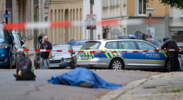 A person lies on a road in Halle, Germany, Wednesday, Oct. 9, 2019. A gunman fired several shots on Wednesday in German city of Halle and at least two got killed, according to local media FOCUS online. (Sebastian Willnow/dpa via AP)